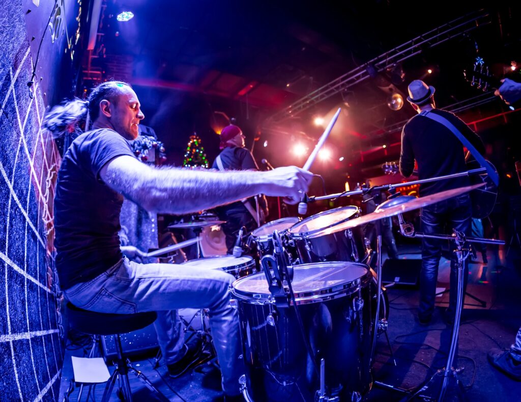 Drummer playing on drum set on stage.