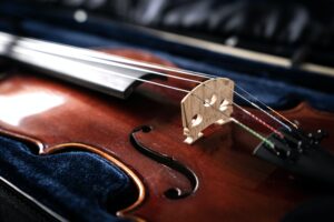 A close up of a syphony violin set against a black background