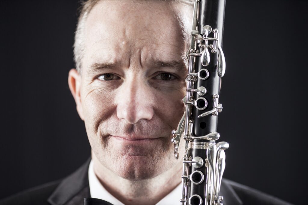 Portrait of man with clarinet over black